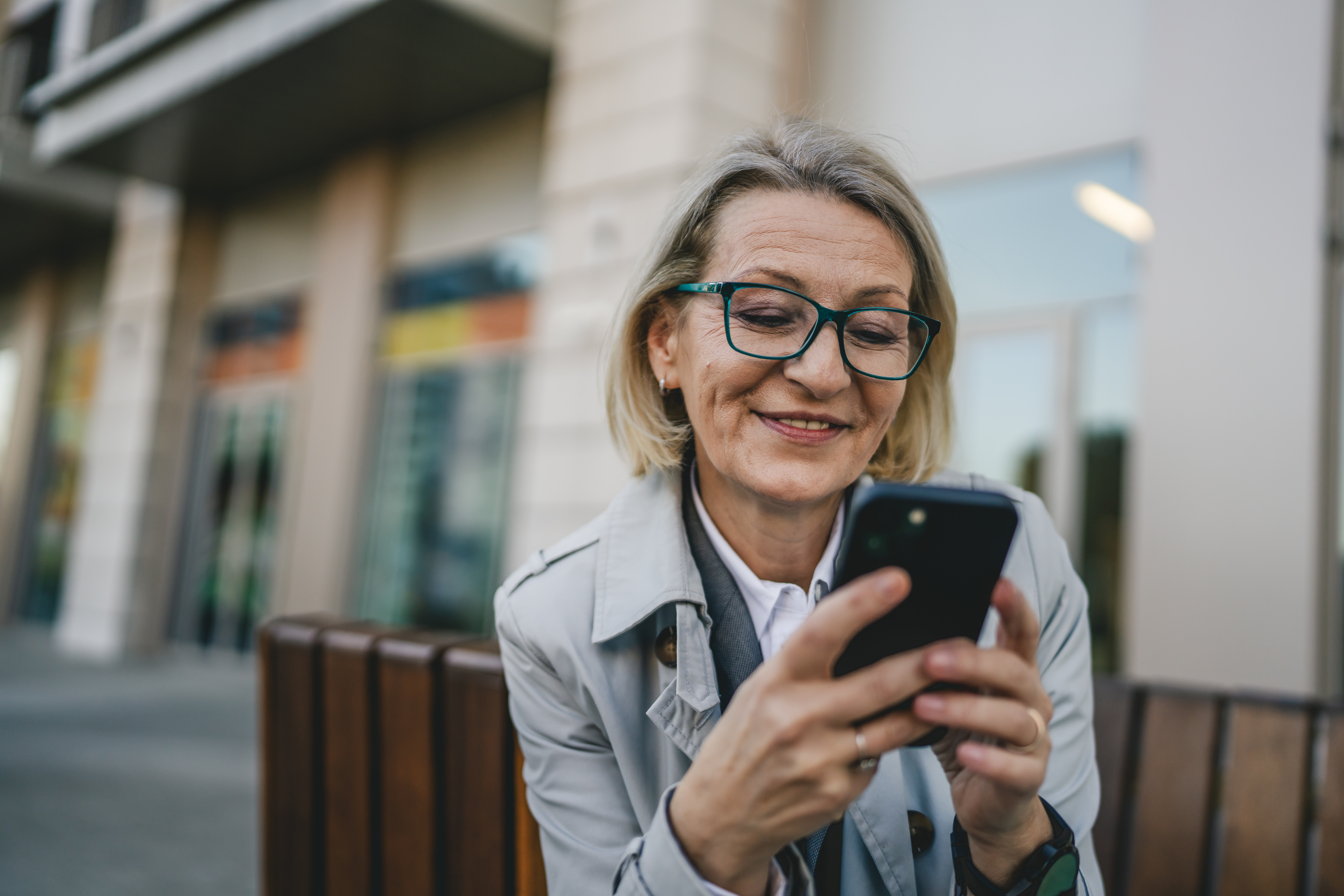 Older woman looking at her phone outside