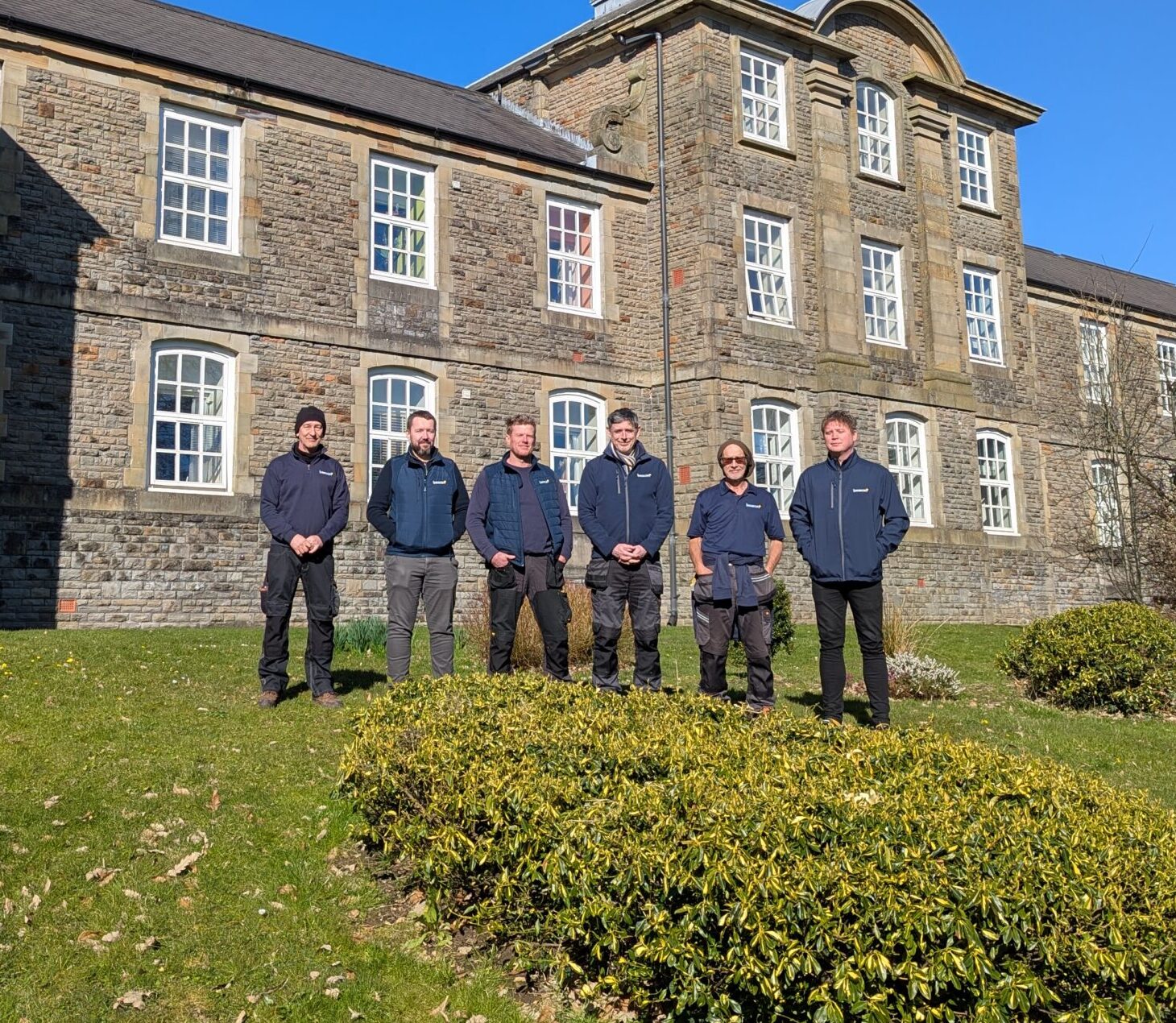 group of staff members stood outside resident building